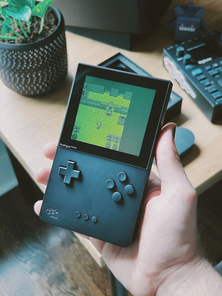 a person holding a gameboy in their hand, Retro Handheld