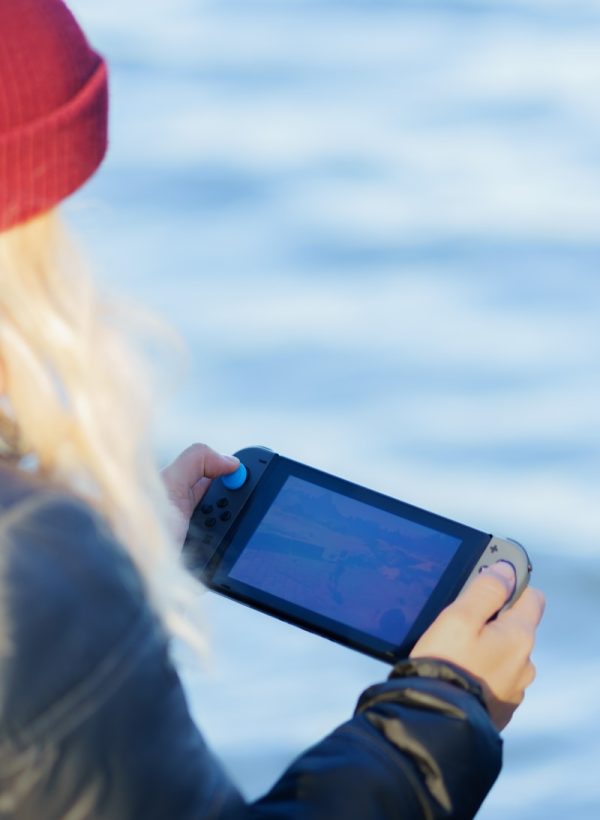 Eine Frau spielt mit ihrer Nintendo Switch Konsole im Freien